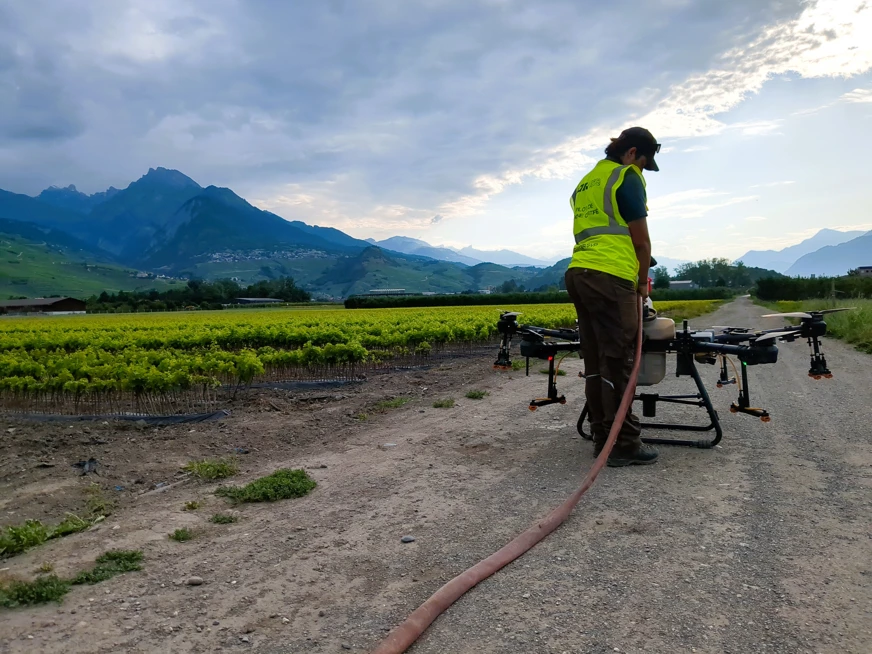Timéo Bétrisey - Apprenti viticuleur rempli un drone devant une pépinière viticole